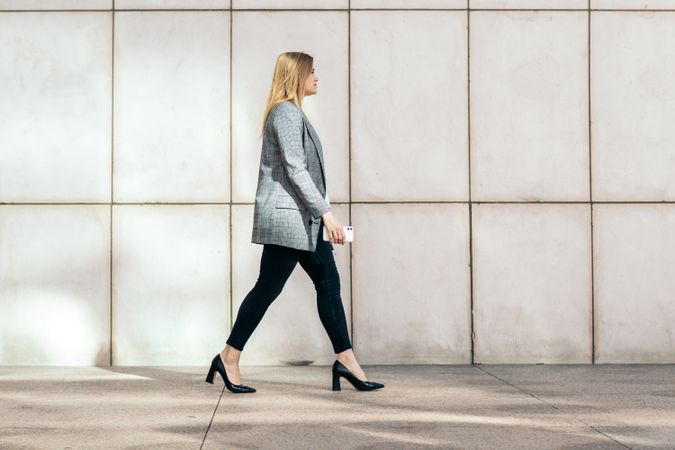 Side view of a businesswoman in a suit and heels on her way to the office