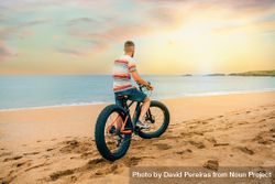 White male sitting on bicycle and looking ahead at beautiful view along the coast bG9Ze5