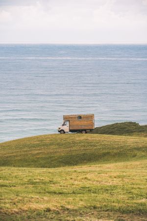 Landscape of empty meadow with passing truck near seaside