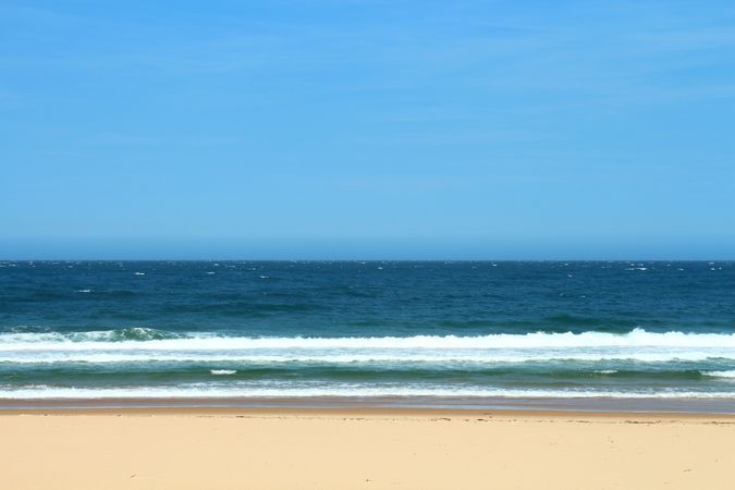 Crowded Sandy Beach With People Enjoying The Waves Of The Blue Ocean On A Summer Day
