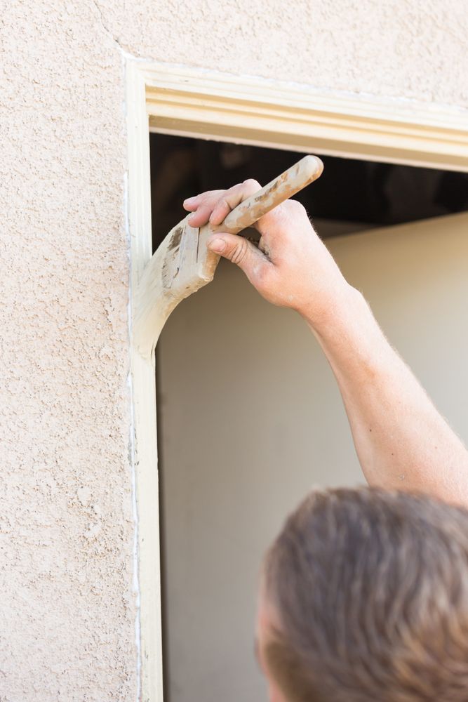 Professional Painter Cutting In With Brush to Paint House Door Frame.