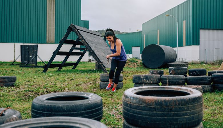 Participant in an obstacle course dragging wheels