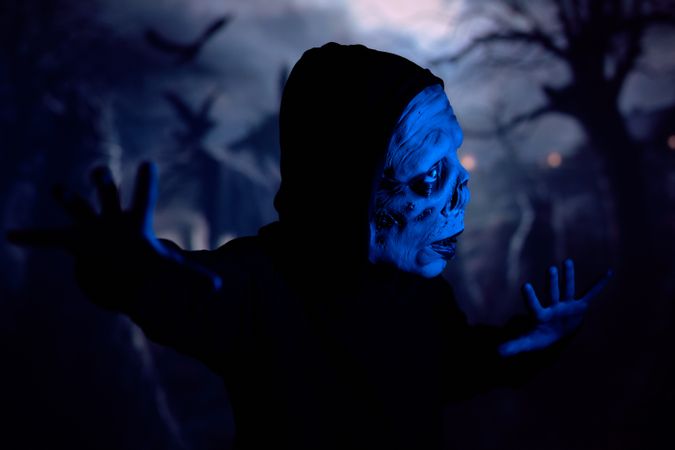 Cautious zombie on dark cemetery