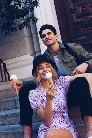 Happy couple feeding each other by ice cream