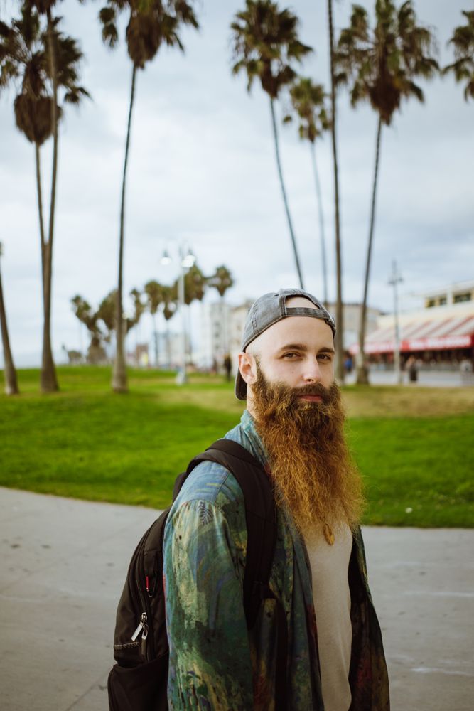 Bearded traveler on pavement in city