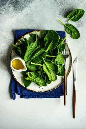 Top view of plate of fresh spinach salad on table