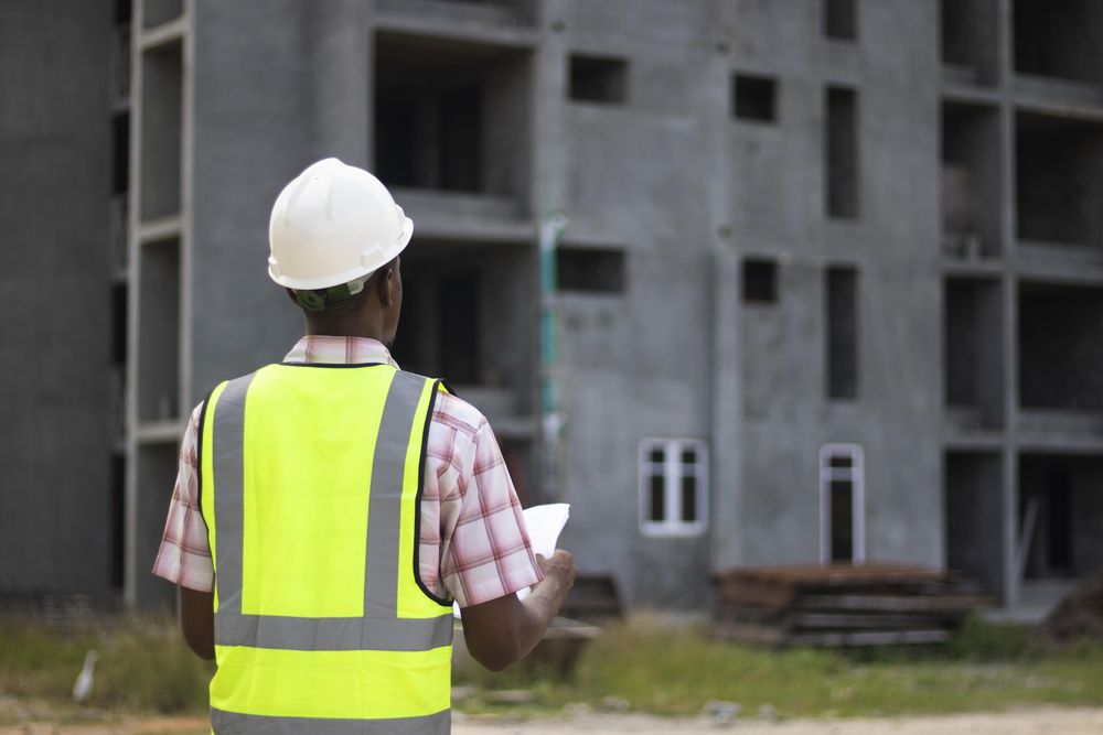 Back view of engineer wearing green vest and hard hat
