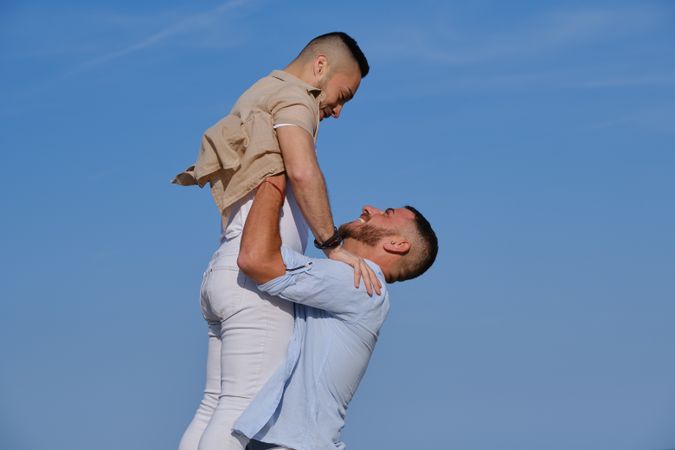 Male couple hugging on beach