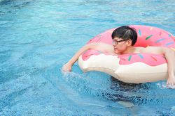 Asian man with inflatable swim ring