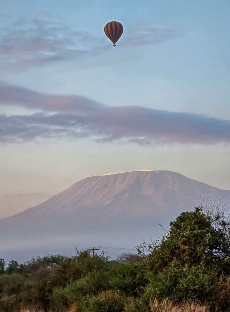 Hot air balloon flying over Mount Kilimanjaro at dawn in Amboseli National Park, Kenya