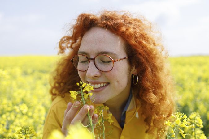 Woman smelling flowers in a field