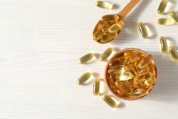 Omega pills in a wooden bowl on a neutral background