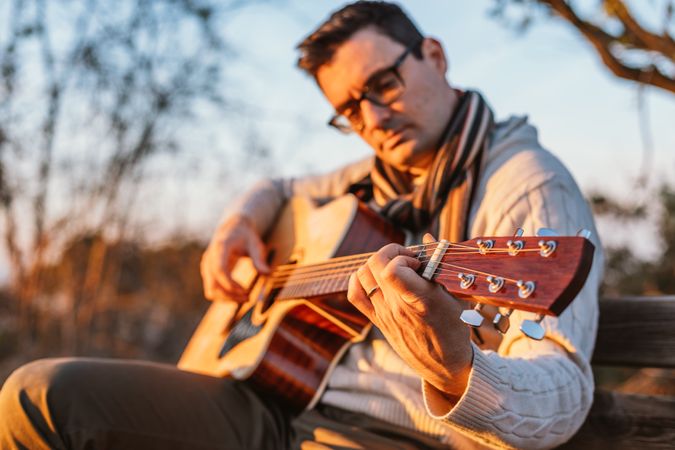 Man playing the guitar on the outside