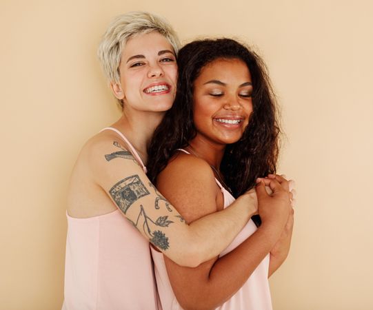 White woman and biracial woman standing together and smiling