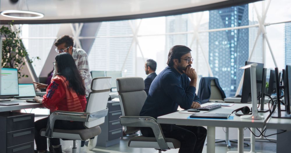 Young Team of Indian Specialists Working on Computers and Having a Conversation in the Office.