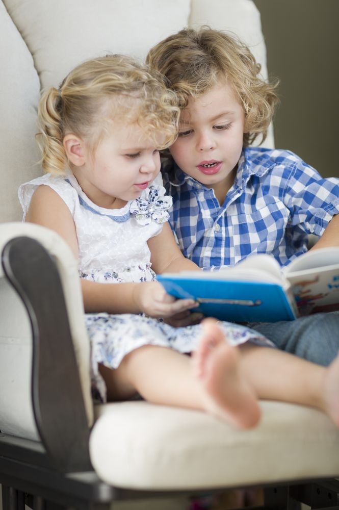 Young Brother and Sister Reading a Book Together