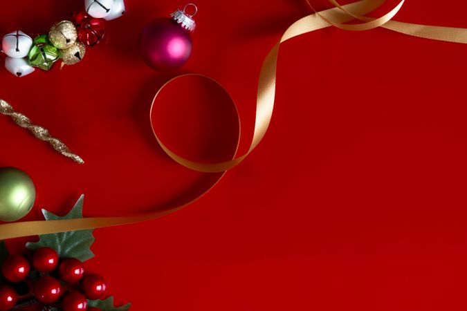 Red Christmas background with ornaments, ribbon, and decorations.