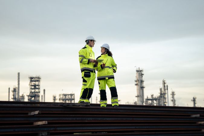 Engineer worker watching work monitor on digital tablet at refinery factory at night