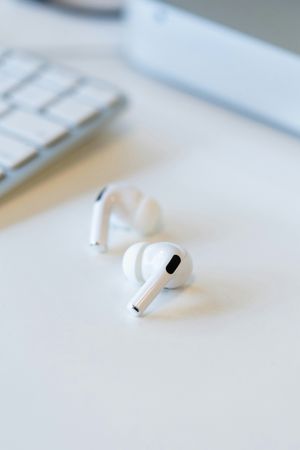 Wireless Earbuds and Keyboard Close-up Detail