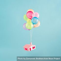 Colorful balloons with pink house flies in the blue sky 0vwdd5