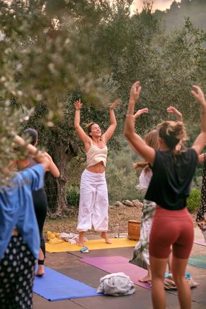 Group of women with instructor stretching in yoga pose