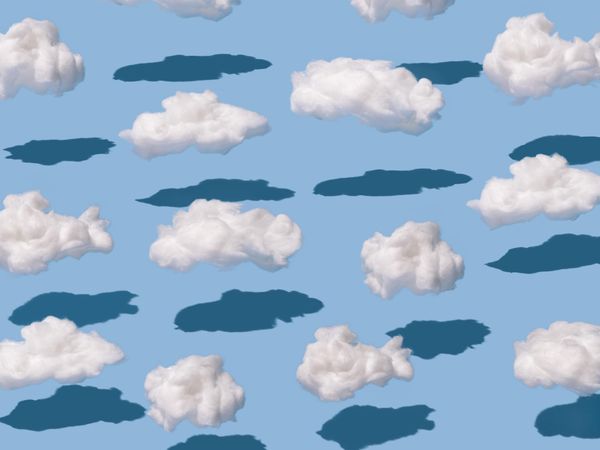 Pattern of fluffy clouds and shadows on blue background