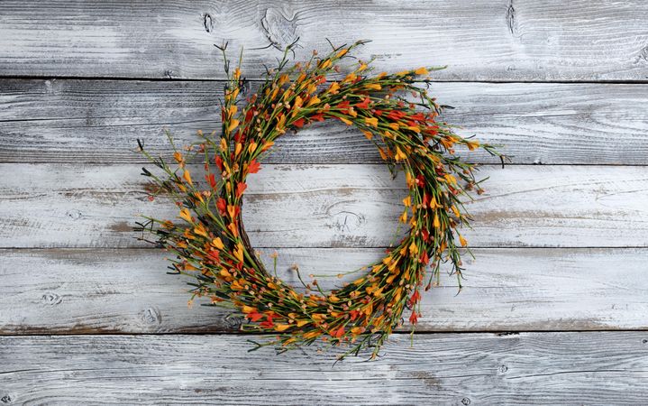 Autumn wreath with small orange flowers on rustic wood