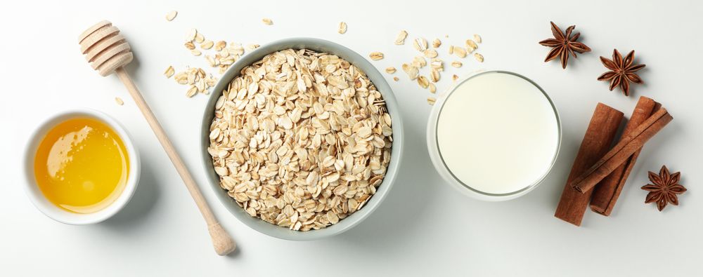Composition with oatmeal flakes on plain background, top view. Cooking breakfast