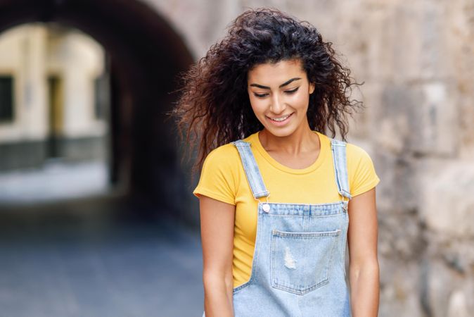 Shy Arab woman walking through quiet street with arch