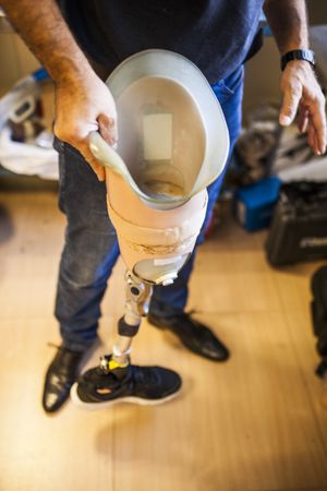 crop man fixing prosthesis in workshop