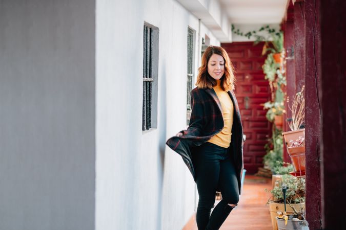 Smiling woman going on corridor in house