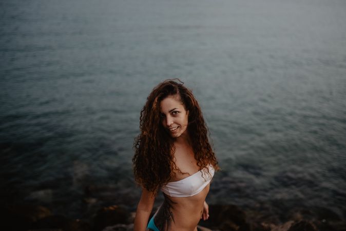 Smiling female standing near sea