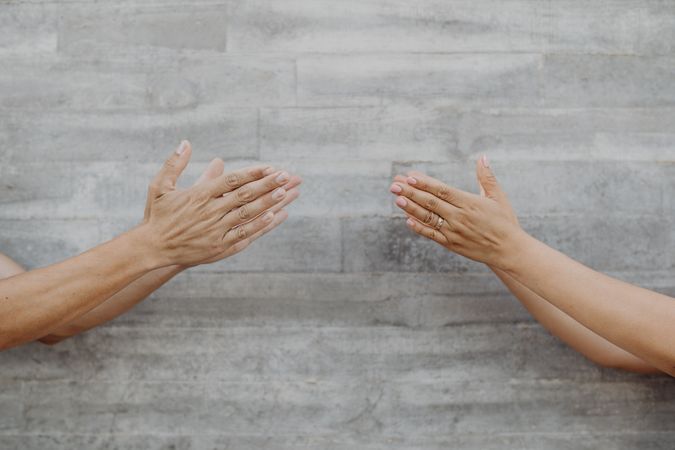 Hands on background of grey wall