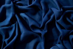 Navy or dark blue fabric wavy crumpled background texture.