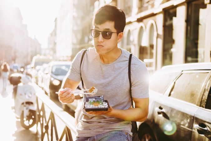 Man eating takeaway food on city street