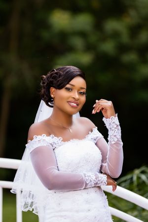 Black woman posing in wedding dress in the park