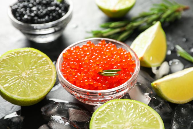 Fresh composition with caviar and citrus on dark table, close up