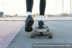 Feet of unrecognizable woman riding on longboard on the the street 5qk9ap