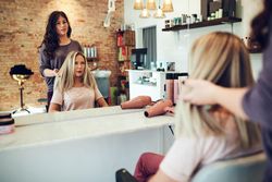 Hair colorist advising woman on best color and cut for client’s hair