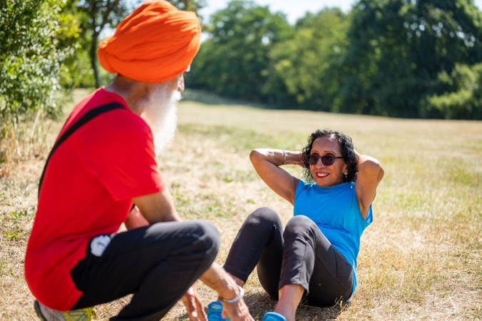 Mature Sikh couple doing sit ups