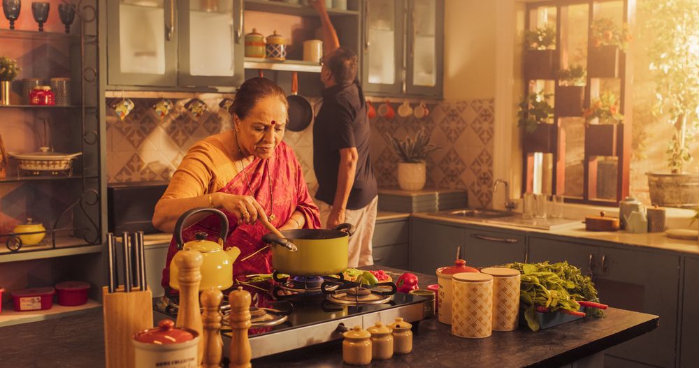 Charming Older Indian Couple Preparing Food Together: Laughing and Talking about their Day