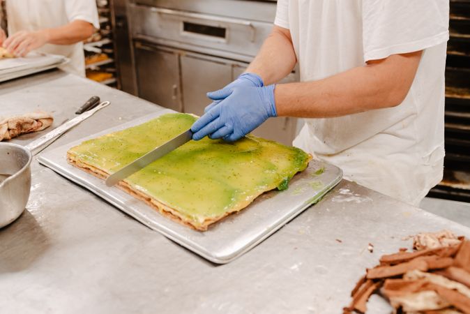 Anonymous cook cutting cake on table