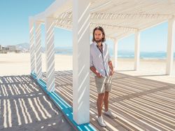 Relaxed man standing in gazebo on beach