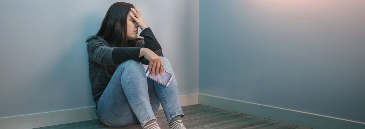 Woman holding mobile desperate for social networks problems
