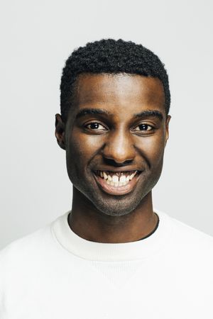 Close up portrait of a smiling Black man in a bright room