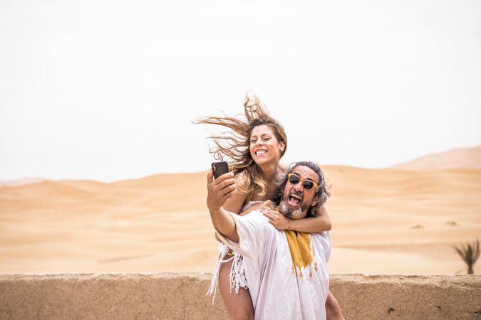 Laughing couple taking selfie on exotic terrace