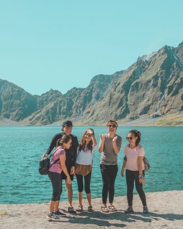 Group of teenage kids smiling beside lake and mountains in Botolan, Central Luzon, Philippines