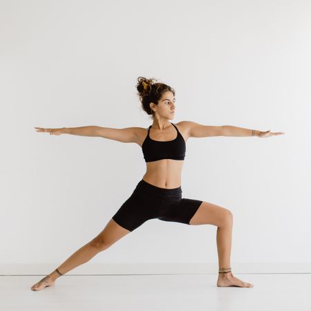 Sportive woman performing yoga pose in room