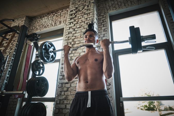 Black man exercising with barbell in gym