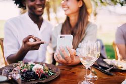 Two friends review the selfie they recently captured at an elegant lunch table
